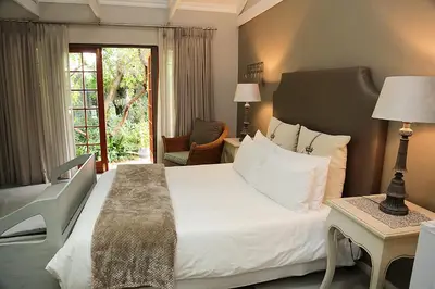 a bedroom with a large white bed and a window at 5 Konings Guesthouse in Paarl