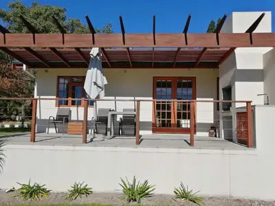 a house with a patio with an umbrella at Lauradale Accommodation in Stellenbosch