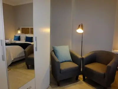 a hotel room with two chairs and a bed at Lauradale Accommodation in Stellenbosch