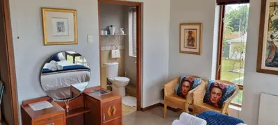 a living room with a mirror and a bedroom at Die Pastorie in Caledon