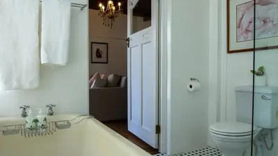 a bathroom with a bath tub and a toilet at Eastcliff Cottage in Hermanus