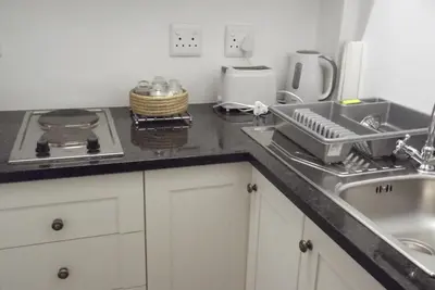 a kitchen with a sink and a counter top at Eastcliff Cottage in Hermanus