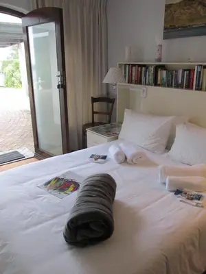a bedroom with a white bed with towels on it at Casa Del Mar in Hermanus
