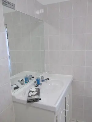 a white bathroom with a sink and a mirror at Casa Del Mar in Hermanus