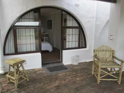 a room with a mirror and two chairs and a bed at Casa Del Mar in Hermanus