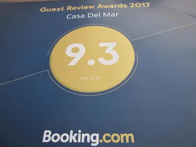 a poster for the quest review awards with a yellow circle at Casa Del Mar in Hermanus