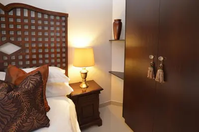 a bedroom with a bed and a table with a lamp at Ridgeworth Boutique Guesthouse in Bellville