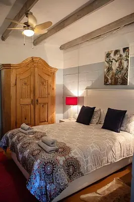 a bedroom with a large bed and a ceiling fan at Maleki in Windmeul