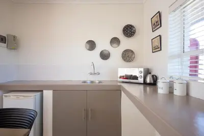 a white kitchen with a sink and a counter at BlackHorse Accommodation in Stellenbosch