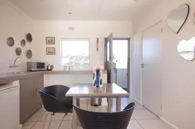 a kitchen with a wooden table and chairs at BlackHorse Accommodation in Stellenbosch