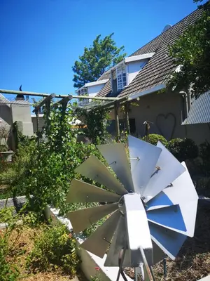 a windmill in front of a house at Almond Cottage Bed & Breakfast in Somerset West