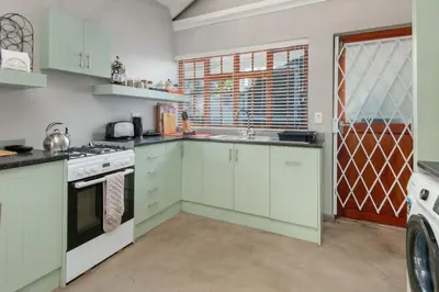 a kitchen with white cabinets and a sink at The Koppie - Accommodation in Hermanus