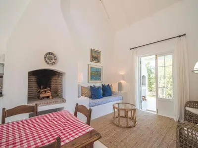 a living room with a table and a fireplace at La Cotte Forest Cottages in Franschhoek