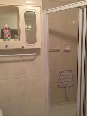 a bathroom with a shower and a glass door at Pebble Moon Holiday Flat in Strand