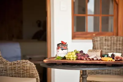 a tray of fruit and cheese on a table at d'Olyfboom Guest House B & B in Paarl