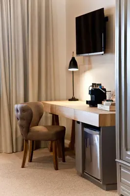 a room with a desk with a chair and a television at d'Olyfboom Guest House B & B in Paarl