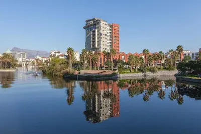 a reflection of a tall building in a body of water at Manhattan Towers 507 by CTHA in Cape Town