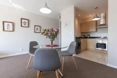 a kitchen and dining room with a table and chairs at Manhattan Towers 507 by CTHA in Cape Town