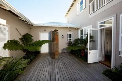 a wooden walkway leading to a house with a door at Vivere in Hermanus