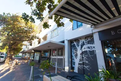 a white building with an awning on a street at 109 on Dorp in Stellenbosch