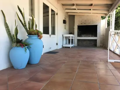 two large blue vases with plants on a patio at Leisure By The Sea in Kleinmond