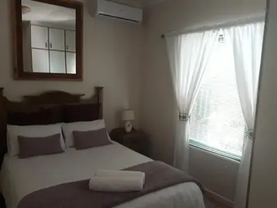 a bedroom with a bed with a mirror and a window at Overmeer in Worcester