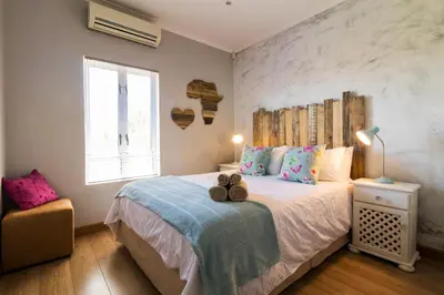a bedroom with a bed with two teddy bears on it at Modern Shabby Chic Apartment in Durbanville