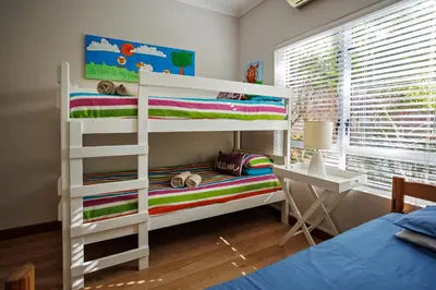 a bedroom with a bunk bed and a desk at Modern Shabby Chic Apartment in Durbanville
