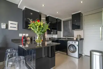 a kitchen with a vase of flowers on a counter at Lux Andringa Walk Apartments in Stellenbosch