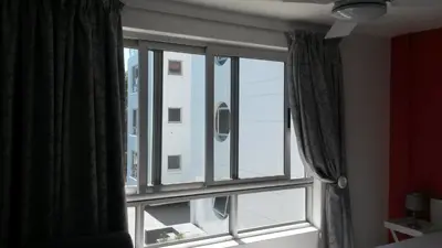 a bedroom window with a view of a building at Sunset 786 Holiday Accommodation Unit-207 in Strand