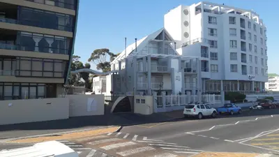a white building on the side of a street at Sunset 786 Holiday Accommodation Unit-207 in Strand