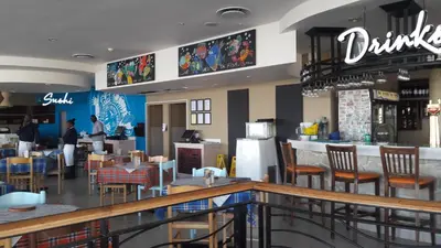 a restaurant with a bar and tables and chairs at Sunset 786 Holiday Accommodation Unit-207 in Strand