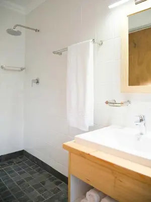 a white bathroom with a sink and a shower at 7 Ackermann Place Guest House in Stellenbosch