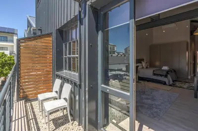 a house with a balcony with a view of a bedroom at Crossfire @ Home in Somerset West