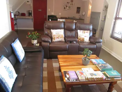 a living room with leather couches and a coffee table at Luxury Secure Flat Apartment in Plattekloof