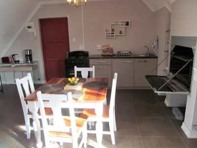 a kitchen with a table and chairs in a kitchen at Luxury Secure Flat Apartment in Plattekloof