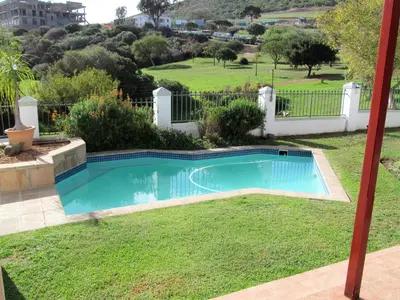a swimming pool in the yard of a house at Luxury Secure Flat Apartment in Plattekloof