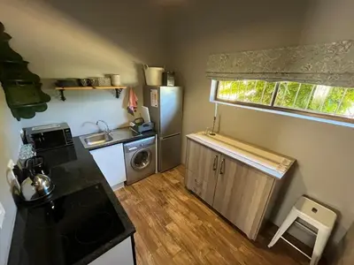 a small kitchen with a sink and a refrigerator at Stellenhaus Guest Cottage in Stellenbosch