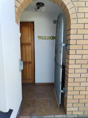 a hallway with a door and a brick wall at 34 On Marten Crescent in Table View