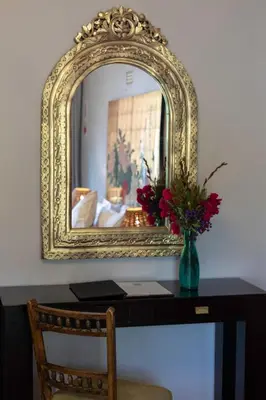 a mirror with a vase of flowers on a desk at Slaley Country House in Stellenbosch