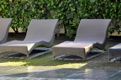 three wicker chairs and a table in a yard at Slaley Country House in Stellenbosch