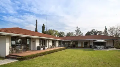 a house with a patio and a grass yard at Slaley Country House in Stellenbosch