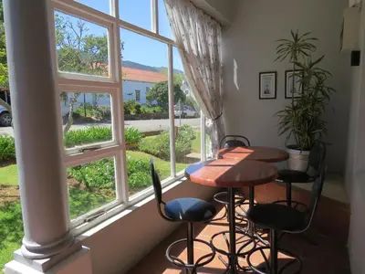 a table and chairs in a room with a window at Swartberg Guest House in Caledon