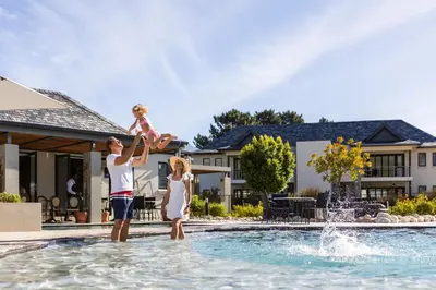 a family playing in the water at a swimming pool at Pearl Valley Hotel in Franschhoek