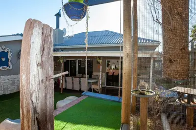 a house with a bird cage in the yard at Strand Guesthouse in Strand