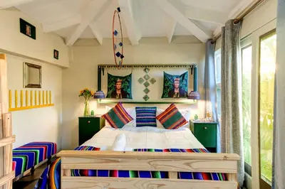 a bedroom with a large bed with colorful pillows at Strand Guesthouse in Strand