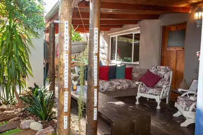 a porch with a couch and chairs on a patio at Strand Guesthouse in Strand
