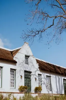 a white house with windows and a roof at Laborie Estate in Paarl