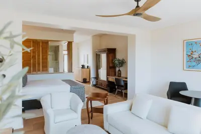 a living room with a white couch and chairs at Laborie Estate in Paarl