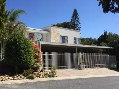 a white house with a fence and flowers at Marshrose Accommodation in Bellville